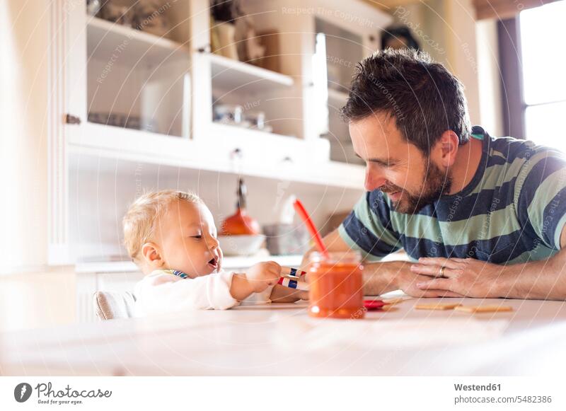Father and baby at home at dining table babies infants father pa fathers daddy dads papa people persons human being humans human beings parents family families