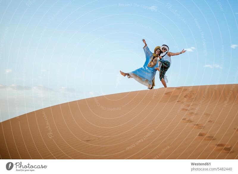 Berber man and woman tourist greeting in the desert Guide female tourist Morocco tourists Travel Deserts Fun having fun funny tourism touristic North Africa