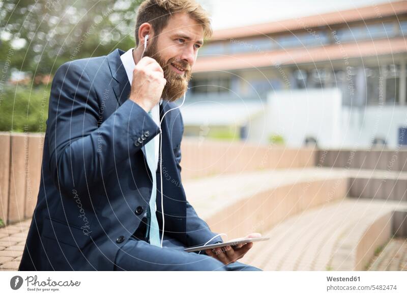 Businessman with using tablet and earphones Business man Businessmen Business men business people businesspeople business world business life ear phone