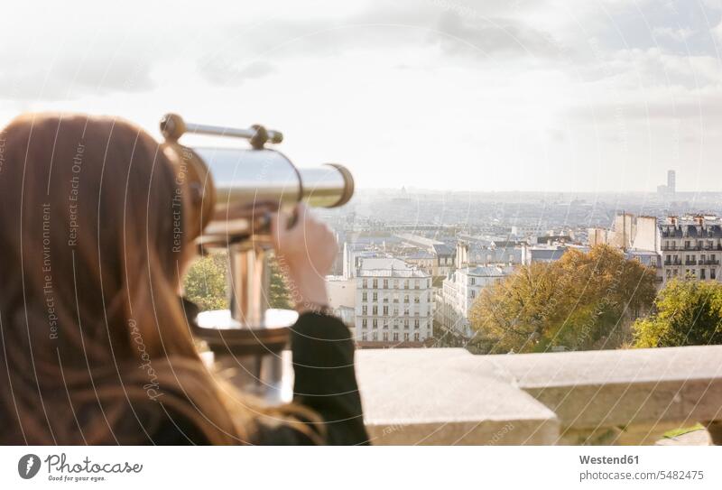 France, Paris, Montmartre, young woman looking through telescope females women View Vista Look-Out outlook view seeing viewing Hand-Held Telescope telescopes