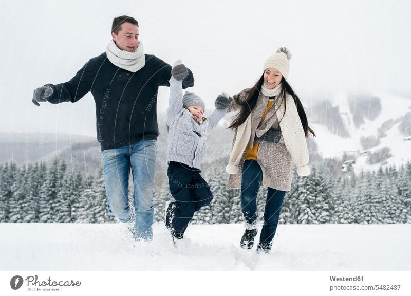 Happy family in winter landscape hibernal families Fun having fun funny happiness happy people persons human being humans human beings snow laughing Laughter