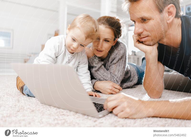 Family using laptop on the floor floors use family families Laptop Computers laptops notebook people persons human being humans human beings computer computers