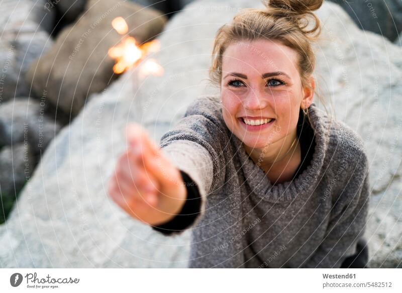 Portrait of smiling young woman holding sparkler outdoors females women portrait portraits sparklers Adults grown-ups grownups adult people persons human being