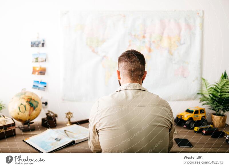 Young traveler planning his next trip from home sitting Seated Traveller Travellers Travelers desk desks Wanderlust Itchy Feet journey travelling Journeys