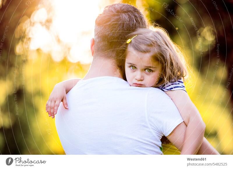 Portrait of sad little girl on father's arms pa fathers daddy dads papa daughter daughters parents family families people persons human being humans