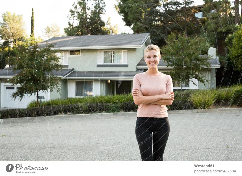 Portrait of smiling woman in front of her home smile females women portrait portraits house houses confidence confident Adults grown-ups grownups adult people