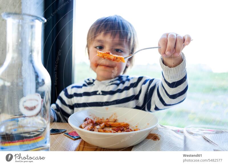 Boy eating pasta with tomato sauce caucasian caucasian ethnicity caucasian appearance european restaurant restaurants one person 1 one person only