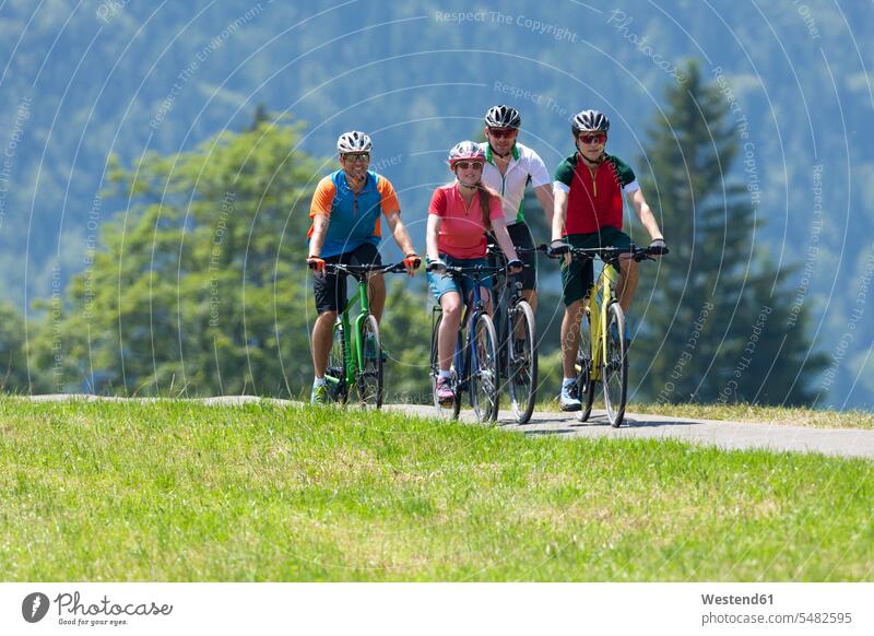Four people on a bicycle tour with trekking bikes caucasian caucasian ethnicity caucasian appearance european Meadow Meadows Activity active path trail paths