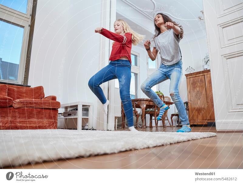 Two girls dancing at home female friends females dance mate friendship child children kid kids people persons human being humans human beings