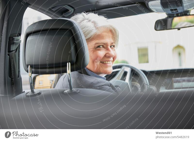 Portrait of smiling businesswoman sitting in a car businesswomen business woman business women automobile Auto cars motorcars Automobiles business people