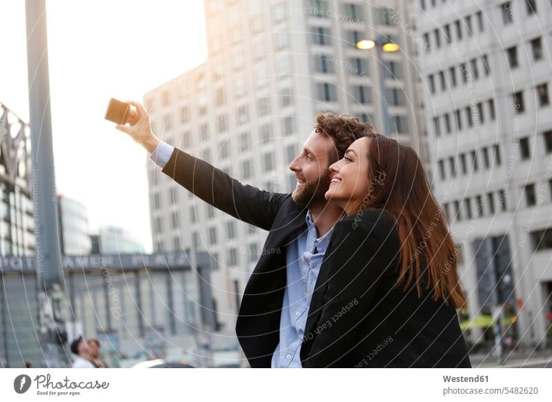 Smiling young businessman and businesswoman taking selfie outdoors Businessman Business man Businessmen Business men Selfie Selfies smiling smile businesswomen