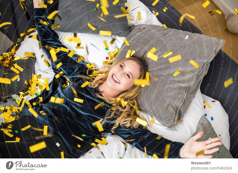 Portrait of happy young woman with flying confetti at home portrait portraits Fun having fun funny females women happiness Adults grown-ups grownups adult