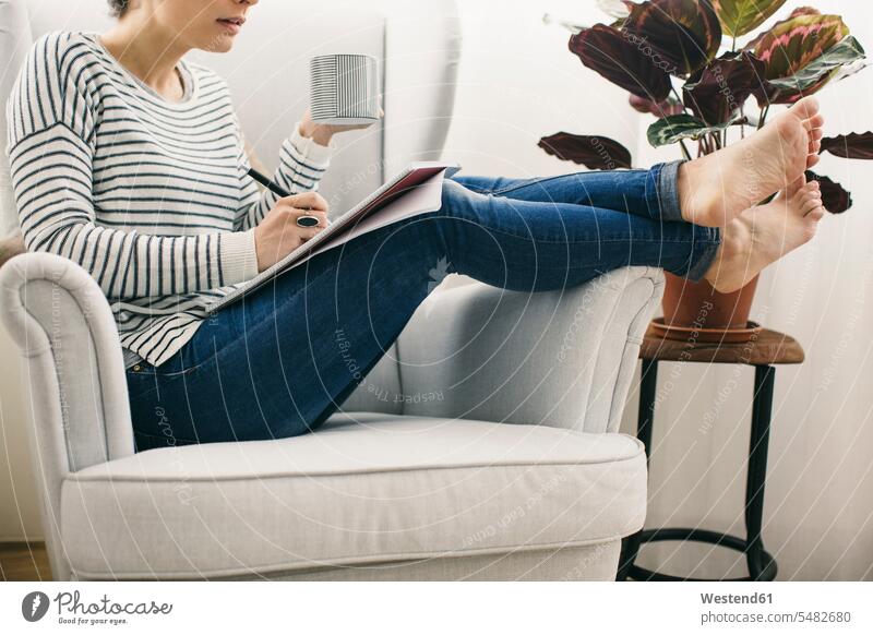 Woman sitting in armchair writing on notepad caucasian caucasian ethnicity caucasian appearance european paper casual leisure wear casual clothing casual wear