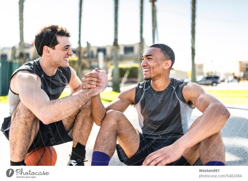 Two young men shaking hands on outdoor basketball court caucasian caucasian ethnicity caucasian appearance european fit multicultural friends mate Enjoyment