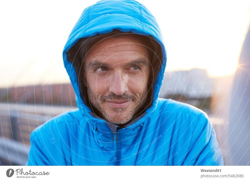 Confident man with hooded jacket in the city urban urbanity Hooded Jackets portrait portraits men males town cities towns urban scene outdoors outdoor shots