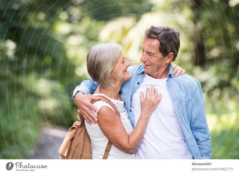 Happy senior couple face to face in the woods looking eyeing twosomes partnership couples forest forests view seeing viewing people persons human being humans