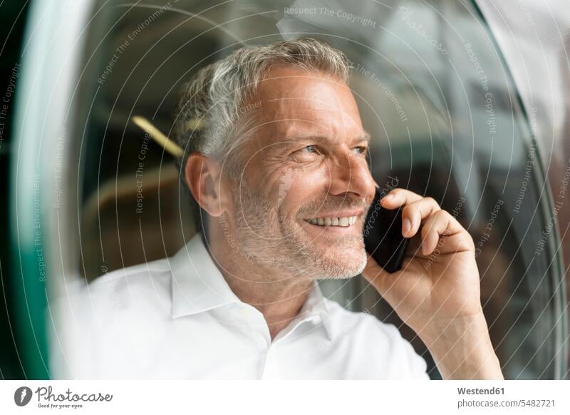 Smiling businessman on cell phone smiling smile mobile phone mobiles mobile phones Cellphone cell phones Businessman Business man Businessmen Business men