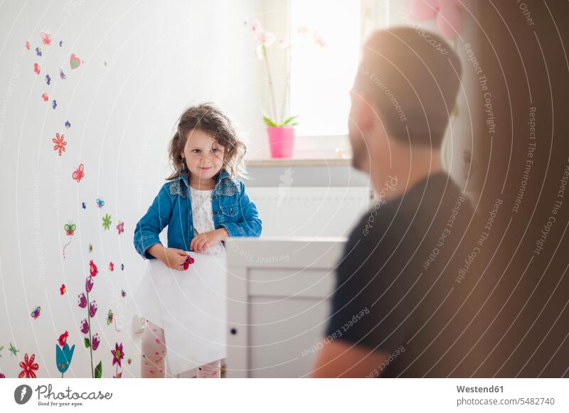 Girl with father decorating wall in children's room pa fathers daddy dads papa daughter daughters decorate parents family families people persons human being