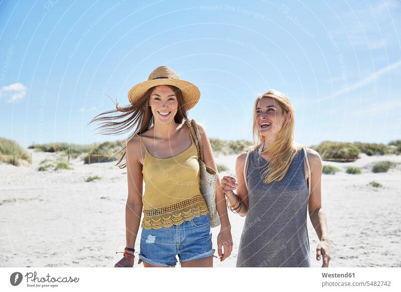 Two happy female friends on the beach smiling smile woman females women vacation Holidays beaches mate friendship Adults grown-ups grownups adult people persons