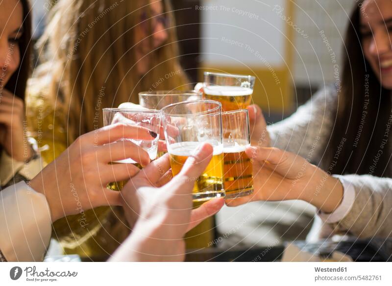 Friends toasting with beer glasses in a street cafe, close-up caucasian caucasian ethnicity caucasian appearance european clinking cheers content pleased Beer