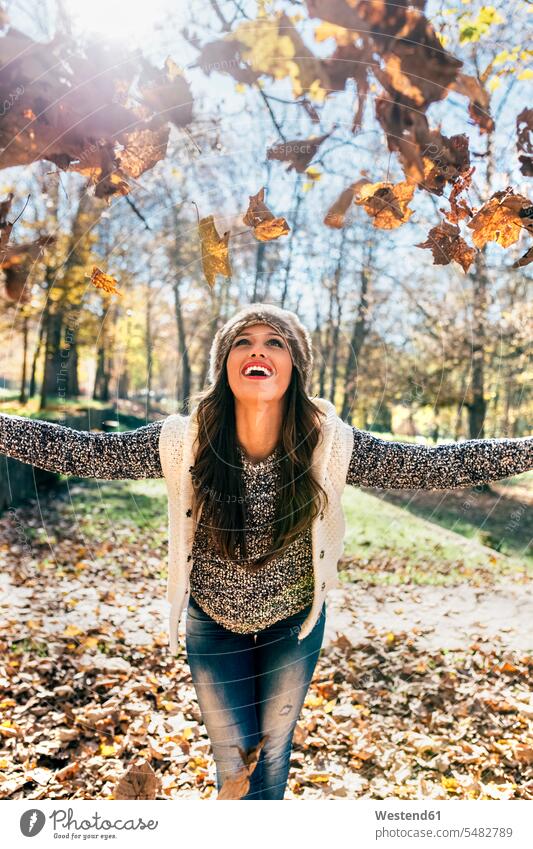 Beautiful happy woman having fun with leaves in an autumnal forest females women portrait portraits fall Fun funny beautiful Leaf Leaves woods forests happiness
