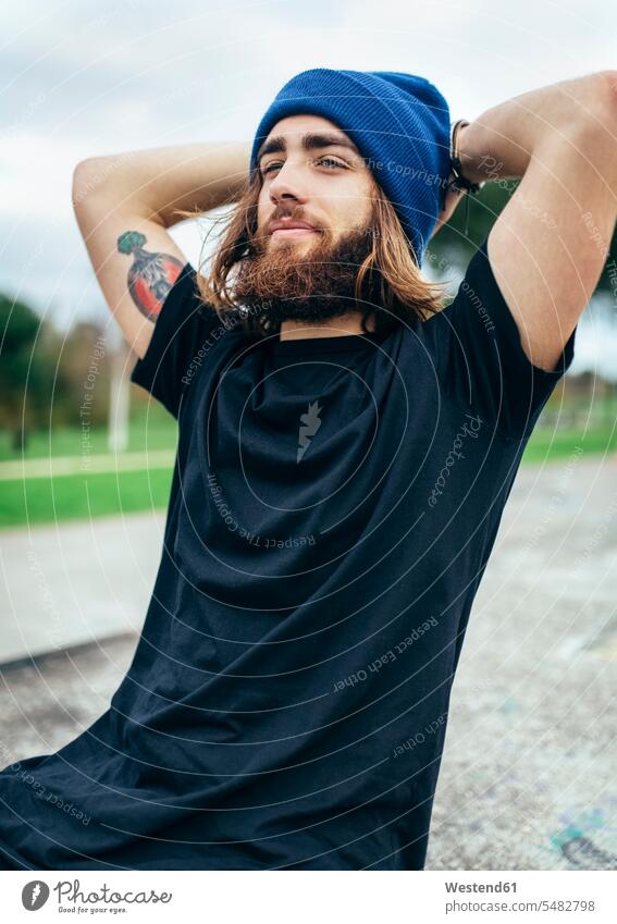 Portrait of bearded young man with tattoo on his upper arm wearing woolly hat caucasian caucasian ethnicity caucasian appearance european tattoos Lifestyles