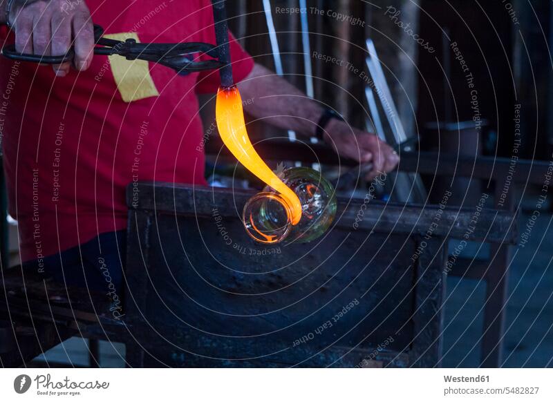 Man working with molten glass in a glass factory glass-blower shaping Forming At Work Job Occupation glassware glassblowing occupation profession