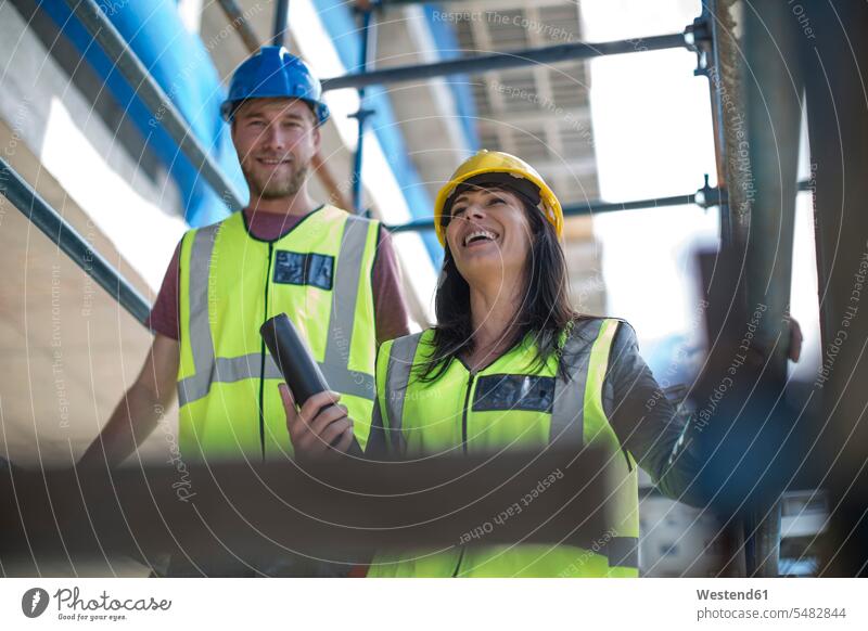 Two engineers inspecting construction site team togetherness confidence confident toothy smile big smile open smile laughing work meeting briefing Cooperation