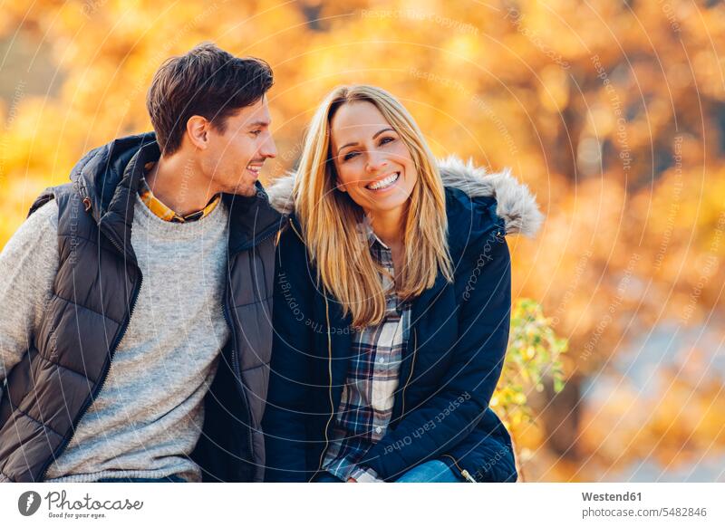 Happy couple enjoying autumn in a forest excursion Getaway Trip Tours Trips happiness happy indulgence enjoyment savoring indulging waist up Waist-Up upper body