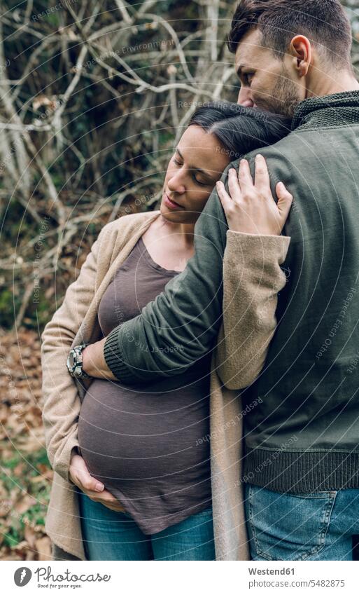 Man with pregnant woman in nature couple twosomes partnership couples Pregnant Woman people persons human being humans human beings standing leaning eyes closed