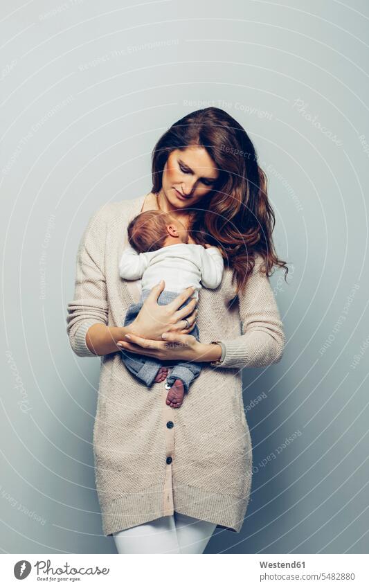 Mother holding her baby mother mommy mothers ma mummy mama infants nurselings babies parents family families people persons human being humans human beings