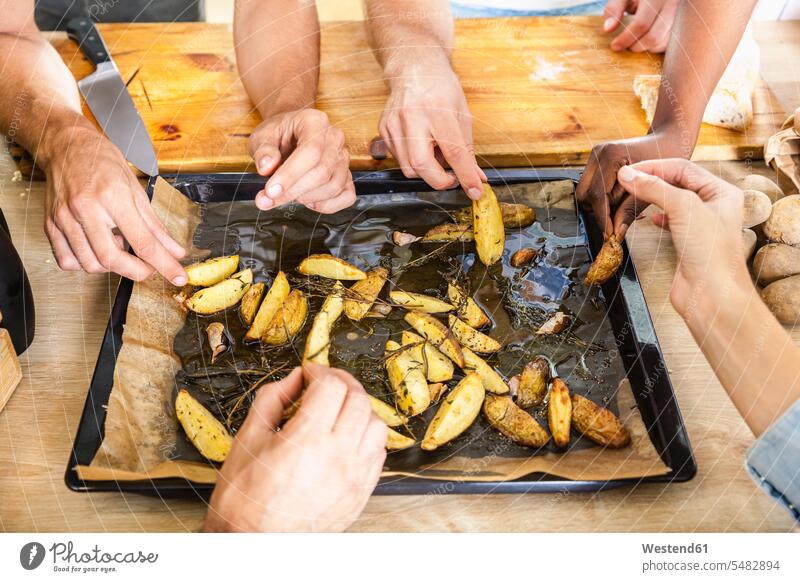 Friends eating potato wedges from baking tray country potatoes Cooking Oil together Lifestyles close-up close up closeups close ups close-ups hand human hand