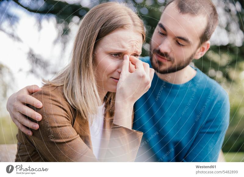 Young man comforting his desperate girlfriend caucasian caucasian ethnicity caucasian appearance european casual leisure wear casual clothing casual wear