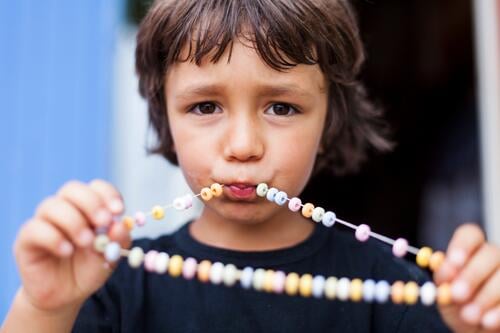 Portrait of little boy with necklace of Hundreds and Thousands caucasian caucasian ethnicity caucasian appearance european sugar bead Nonpareils sugar beads