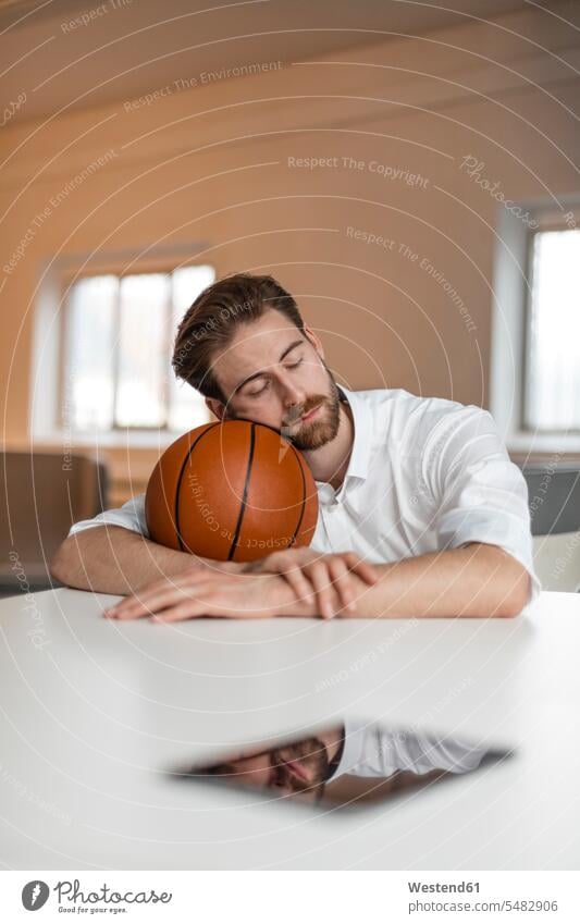 Portrait of young freelancer with basketball having a break freelancing basketballs Basketball sport sports sitting Seated resting loft lofts portrait portraits