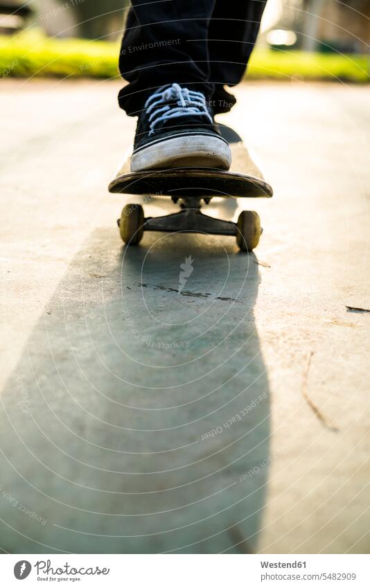 Feet of a skateboarder on a skateboard Skate Board skateboards man men males skater skateboarders skaters Adults grown-ups grownups adult people persons