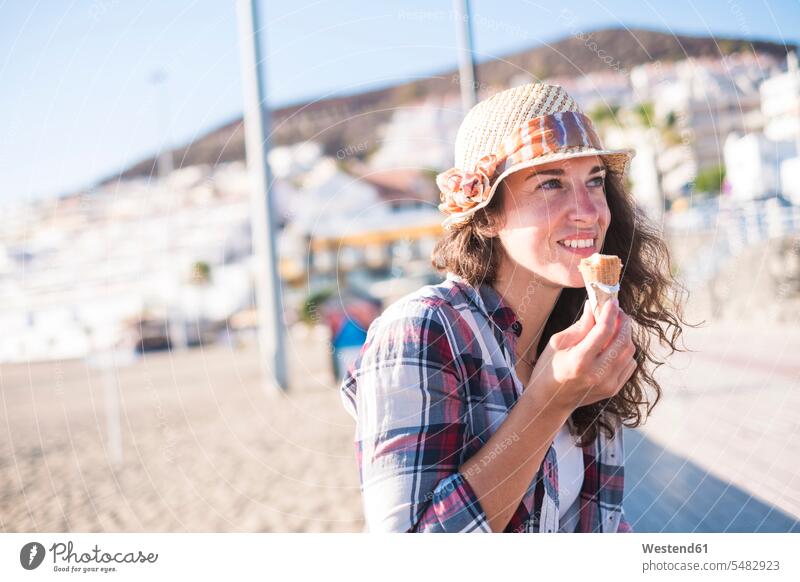 Young woman eating ice cream on the beach females women vacation Holidays icecream Ice Creams ice-cream summer summer time summery summertime Adults grown-ups