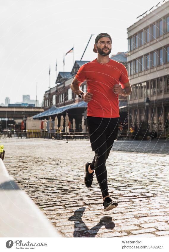 USA, New York City, man running on cobblestone pavement males Jogging New York State United States United States of America Adults grown-ups grownups adult