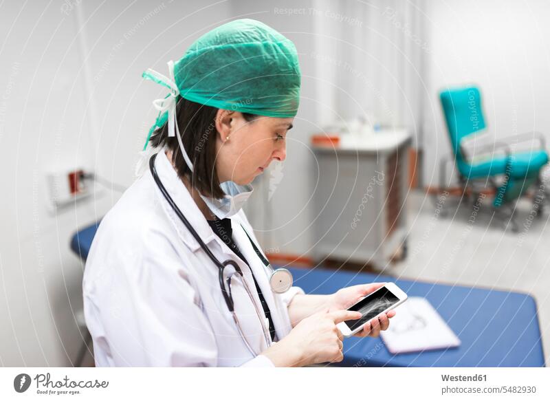 Doctor using smartphone Female Doctor physicians Female Doctors woman females women mobile phone mobiles mobile phones Cellphone cell phone cell phones doctor