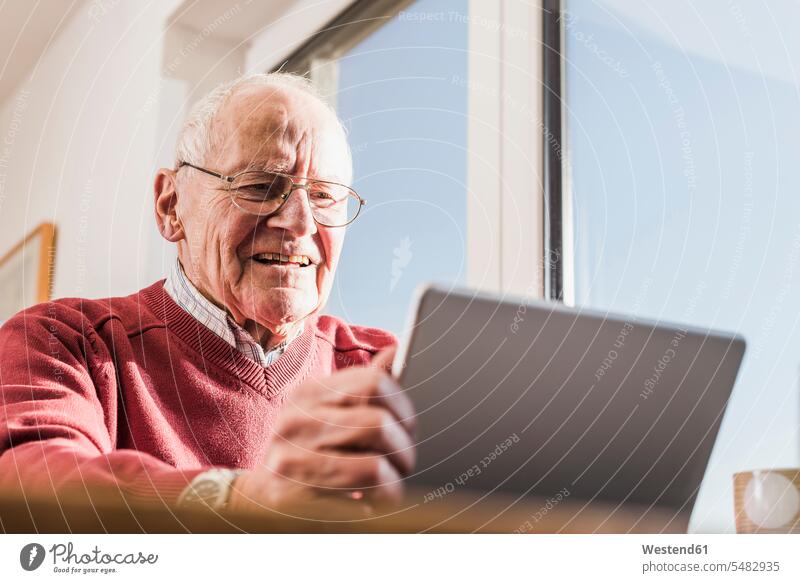 Senior man sitting at home, using laptop Laptop Computers laptops notebook use pensioner pensioners retirees online Surfing the Net senior men senior man
