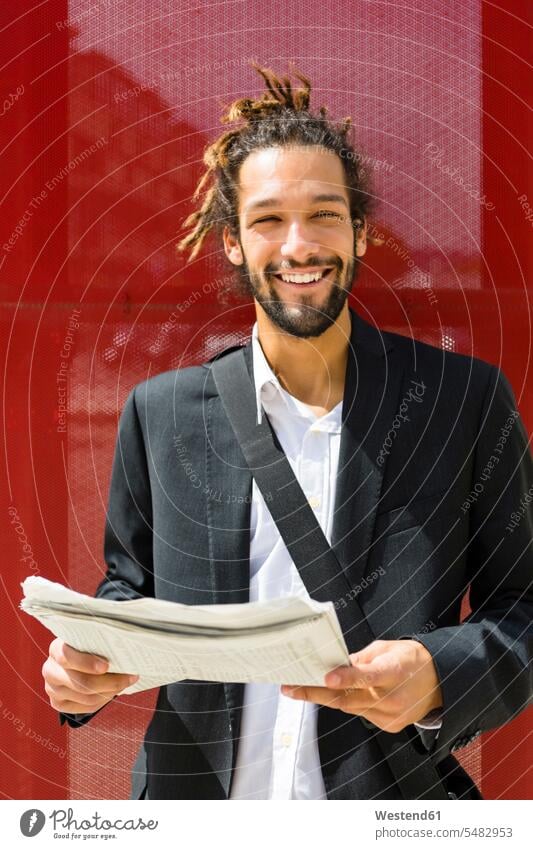 Portrait of young businessman with dreadlocks reading newspaper newspapers Businessman Business man Businessmen Business men portrait portraits business people