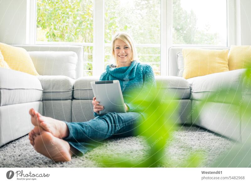 Portrait of happy woman with tablet in living room portrait portraits smiling smile digitizer Tablet Computer Tablet PC Tablet Computers iPad Digital Tablet