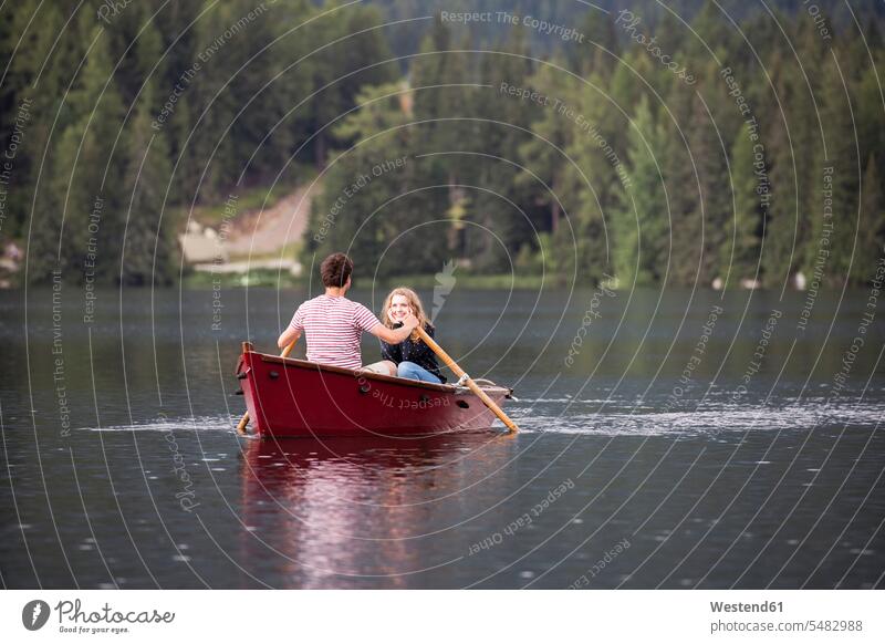 Young couple in rowing boat on the lake Oaring lakes twosomes partnership couples water waters body of water people persons human being humans human beings