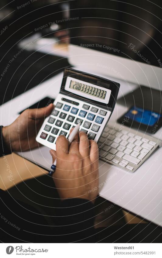 Man using calculator at desk, partial view hand human hand hands human hands people persons human being humans human beings buying desks typing type use men