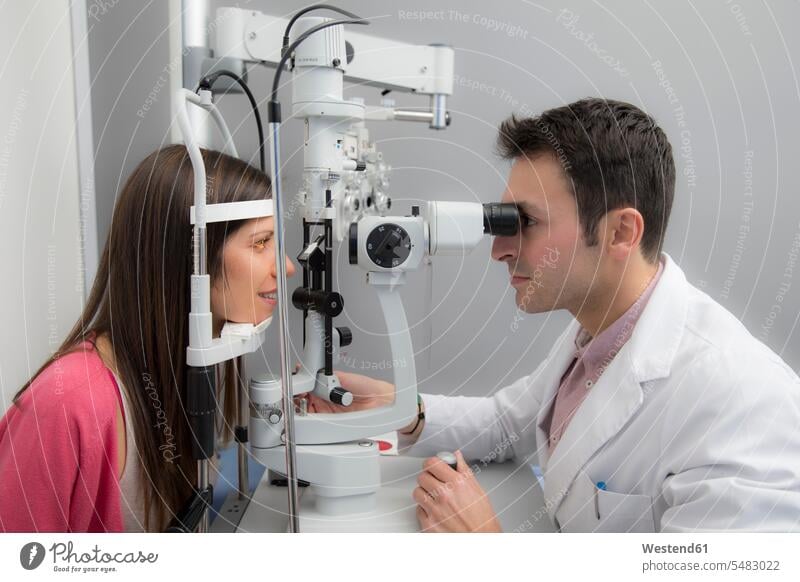Woman at the optometrist making an eye test testing checking Test Check expertise competence competent Optometry mid adult women mid adult woman mid-adult women