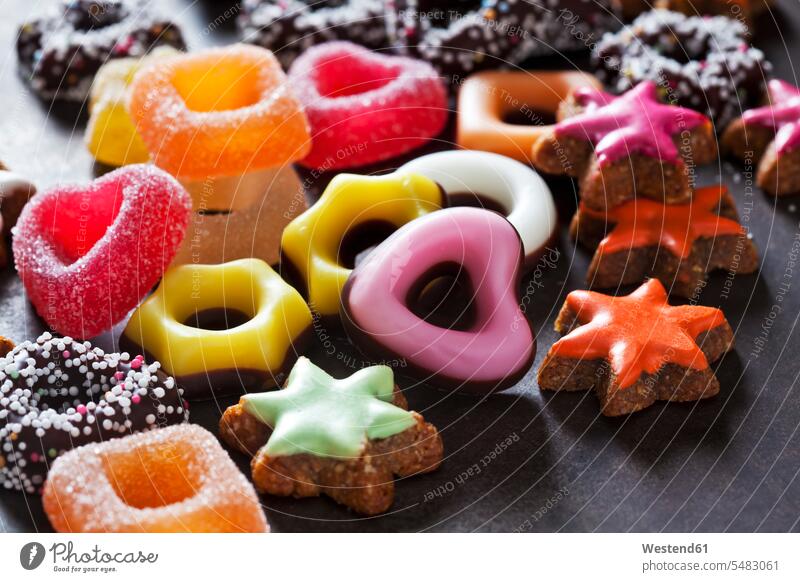 Jelly confectionery, coloured cinnamon stars and other Christmas cookies on dark ground food colouring food coloring selection Assortment offer offering choice
