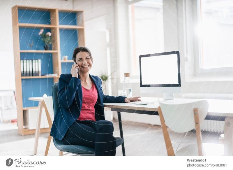 Portrait of businesswoman sitting at desk in a loft portrait portraits females women Adults grown-ups grownups adult people persons human being humans