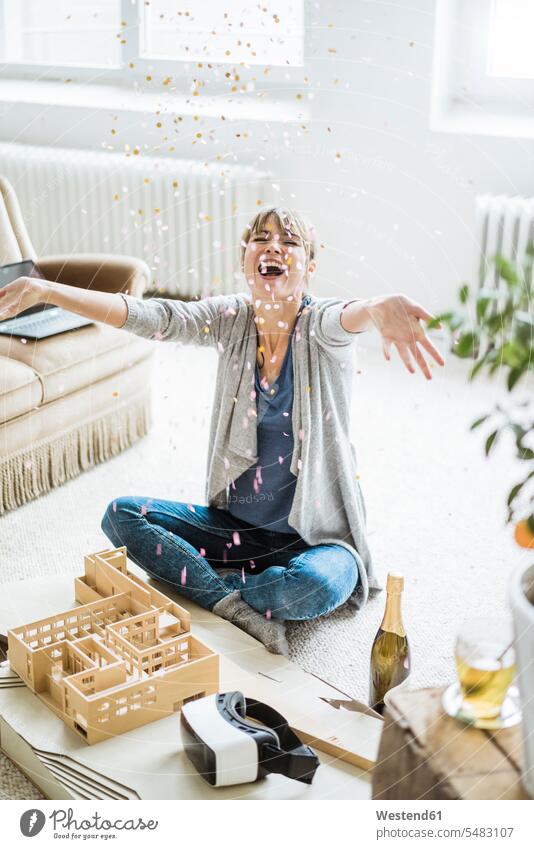 Confetti falling on happy woman in office with architectural model models confetti Architecture portrait portraits Office Offices females women tumbling tumble