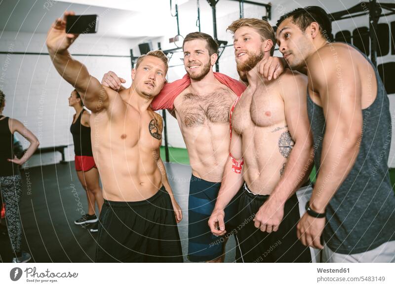 Four athletes in gym taking selfie six pack sixpack muscular muscles athletic Six Pack Washboard Stomach Six-Sack exercising exercise training practising