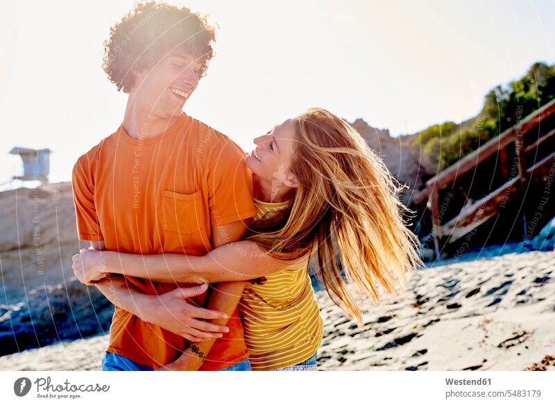 Playful couple on the beach happiness happy embracing embrace Embracement hug hugging beaches twosomes partnership couples laughing Laughter people persons